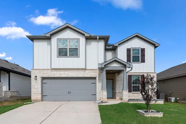 a front view of a house with a yard and garage