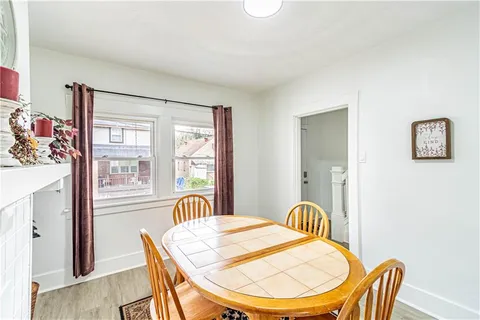 a view of a dining room with furniture a chandelier and wooden floor