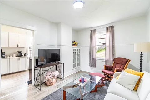 a living room with furniture a flat screen tv and a window