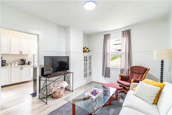 a living room with furniture a flat screen tv and a window