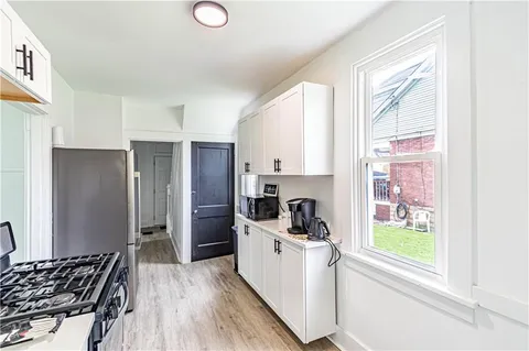 a kitchen with a refrigerator a stove a sink and a window