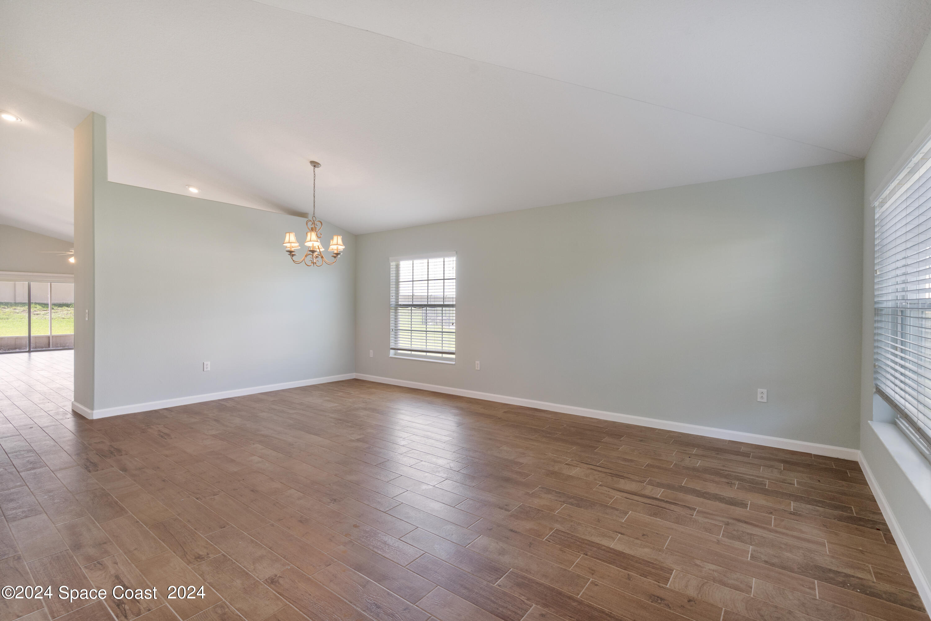 4220 Chardonnay Drive Rockledge, FL 32955 - Photo 14 of 51 an empty room with wooden floor and windows