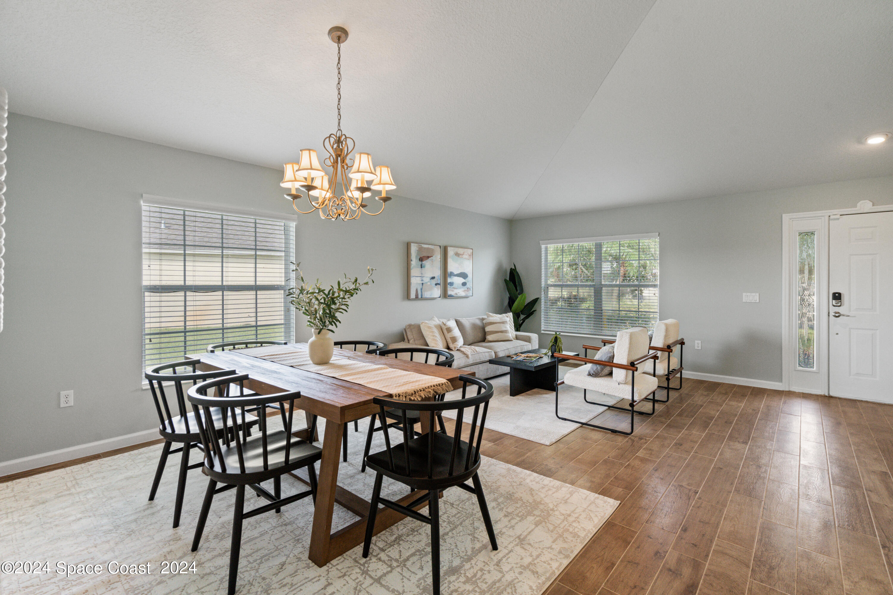 4220 Chardonnay Drive Rockledge, FL 32955 - Photo 6 of 51 a dining room with wooden floor a chandelier a wooden table and chairs