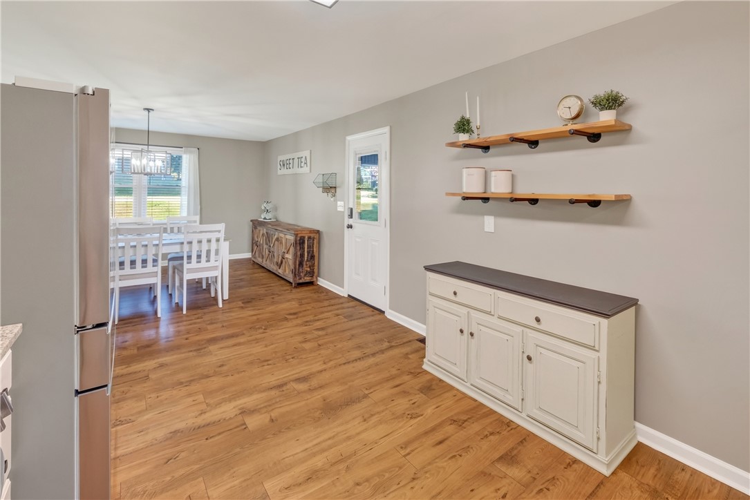 207 Ridgecrest Drive Williamston, SC 29697 - Photo 7 of 22 Rich wood-inspired flooring anchors this open dining space illuminated by natural light.