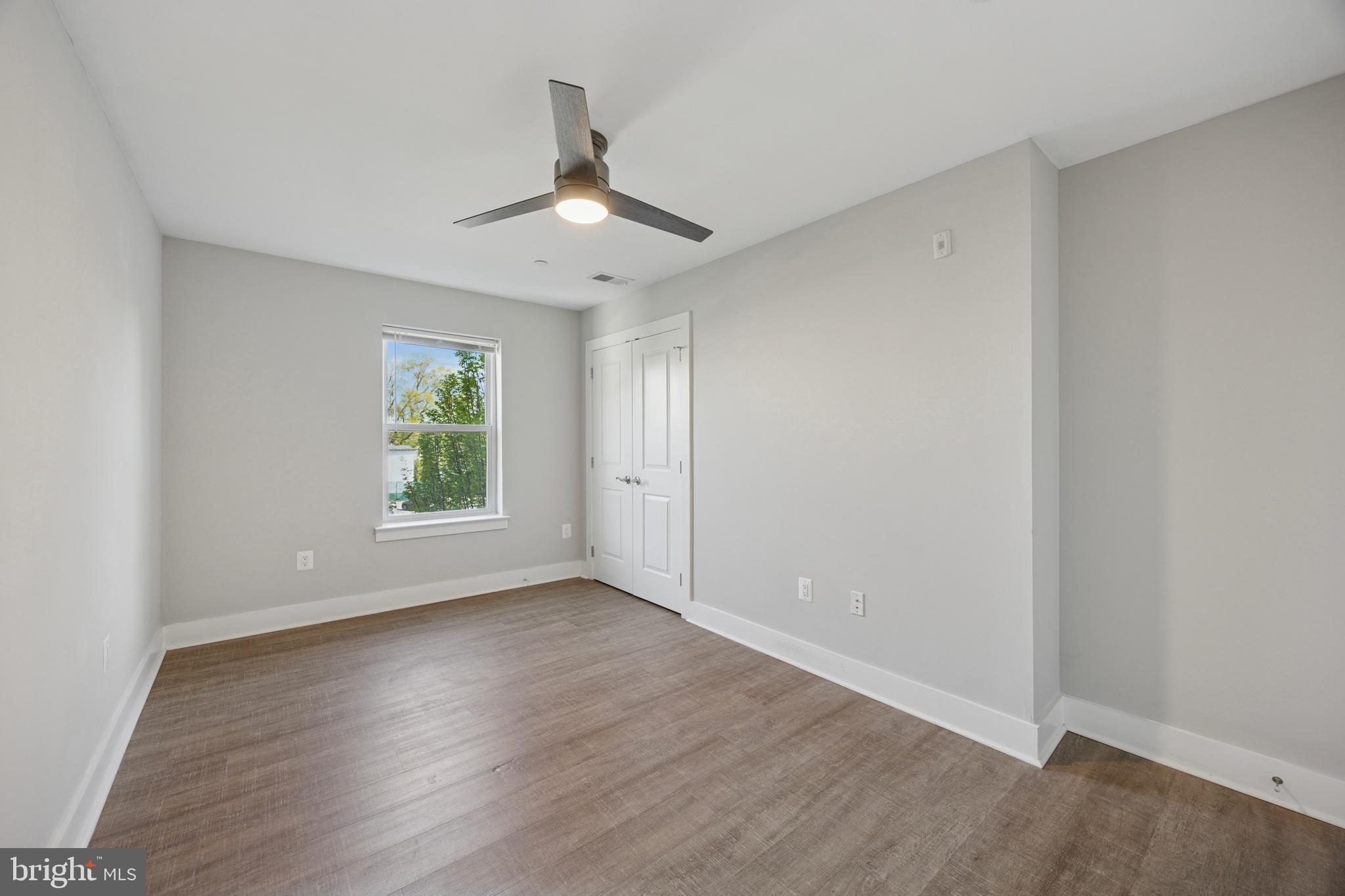 502 Gerhard Street, Unit J Philadelphia, PA 19128 - Photo 19 of 25 an empty room with wooden floor chandelier fan and windows