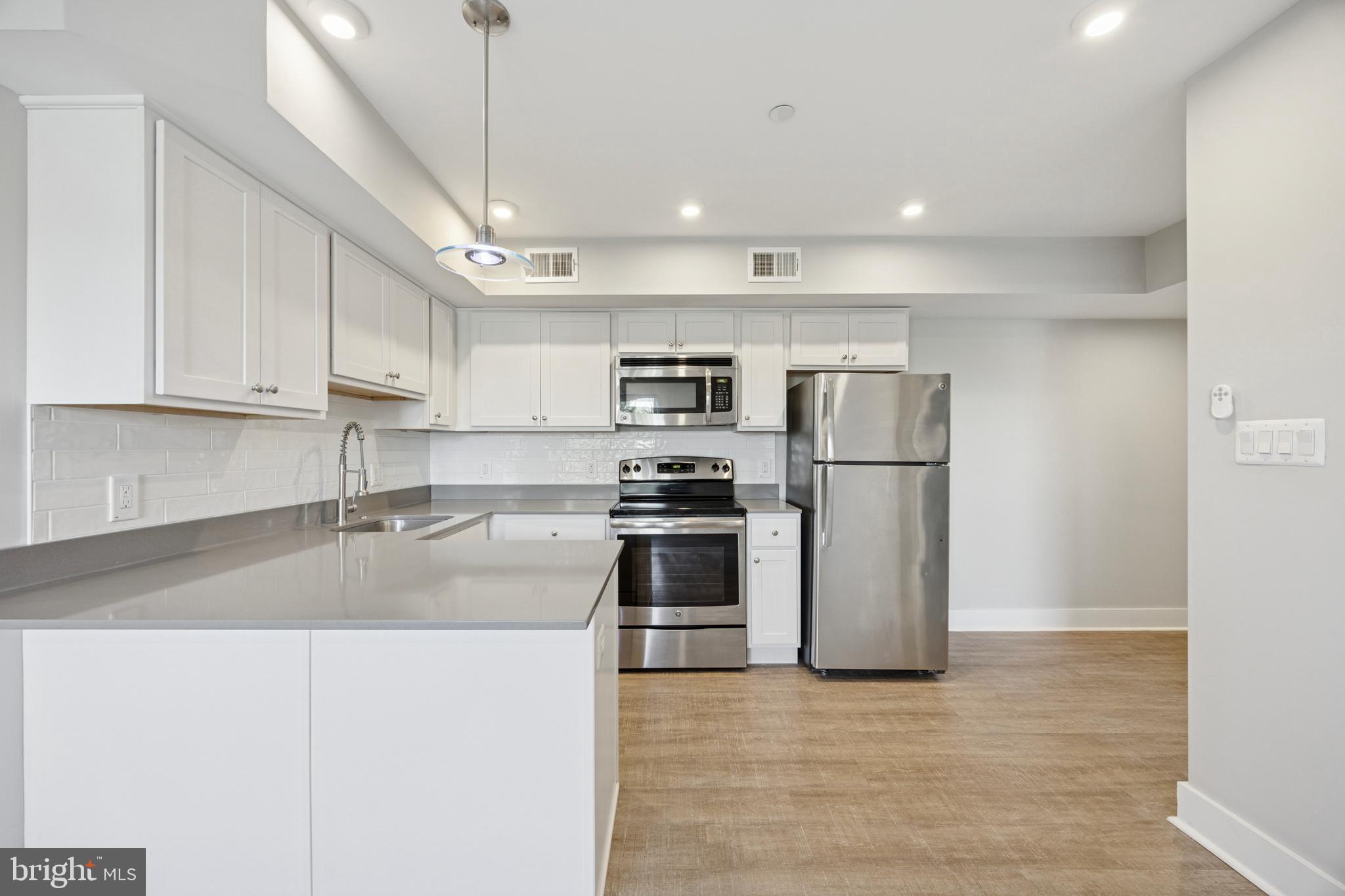 502 Gerhard Street, Unit J Philadelphia, PA 19128 - Photo 10 of 25 a kitchen with stainless steel appliances granite countertop a refrigerator a stove a sink and a microwave