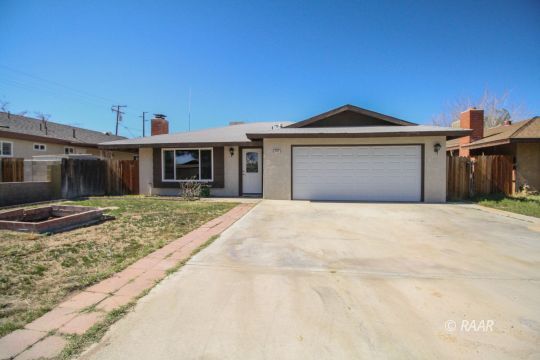 237 South American Street Ridgecrest, CA 93555 - Photo 1 of 26 a front view of a house with a yard and garage