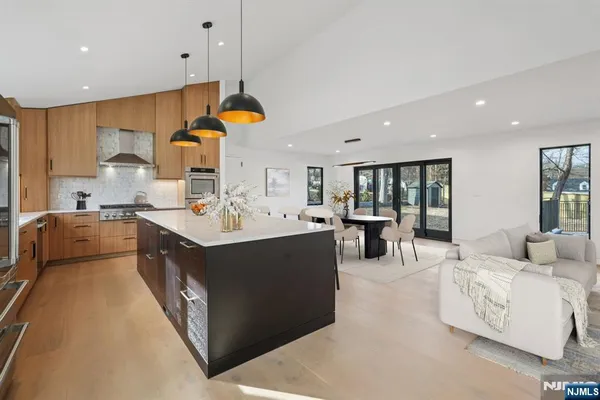 a kitchen with kitchen island a sink and a stove with wooden floor