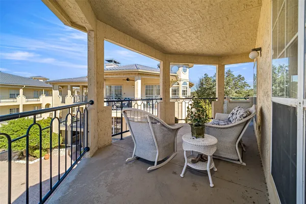 a balcony filled with furniture and potted plants