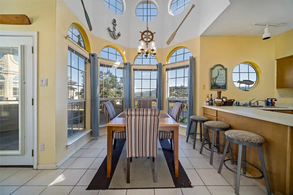 a kitchen with stainless steel appliances granite countertop a stove a sink dishwasher a refrigerator with a dining table and chairs with wooden floor