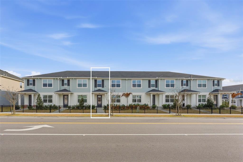 a view of a building with a big yard and a large tree