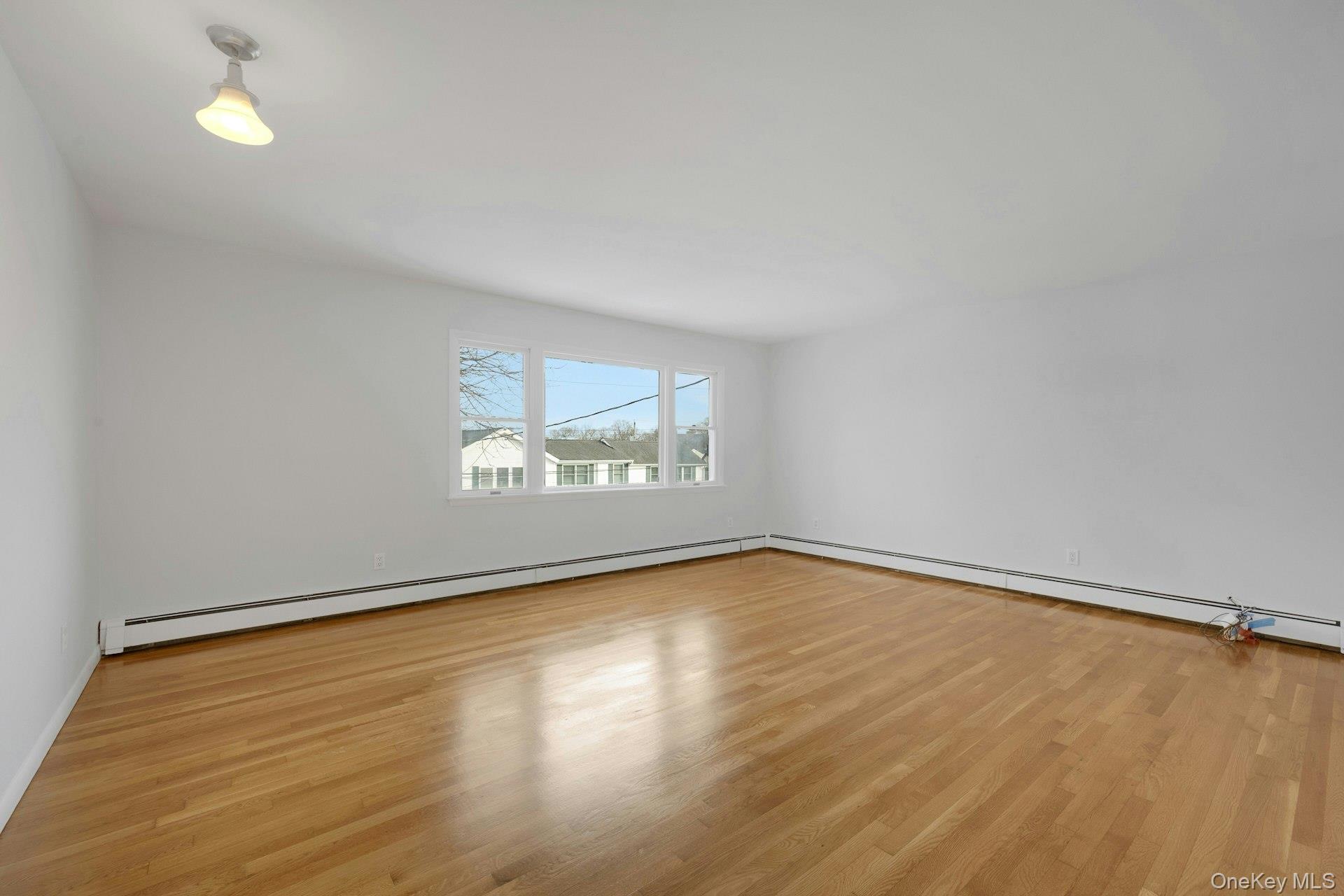 52 Post Place, Unit 2 Harrison, NY 10528 - Photo 3 of 23 an empty room with wooden floor and windows