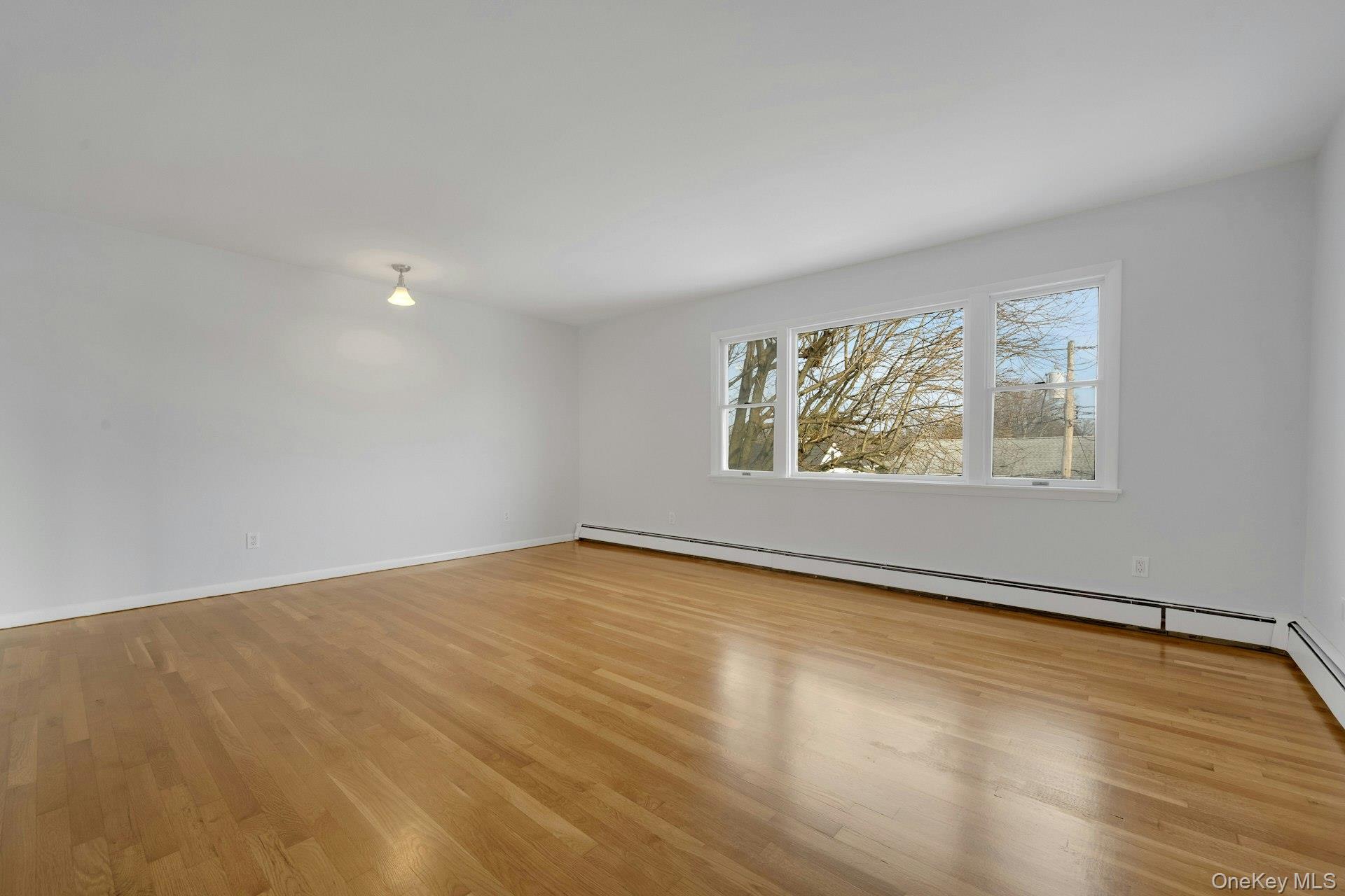 52 Post Place, Unit 2 Harrison, NY 10528 - Photo 4 of 23 wooden floor in an empty room with a window