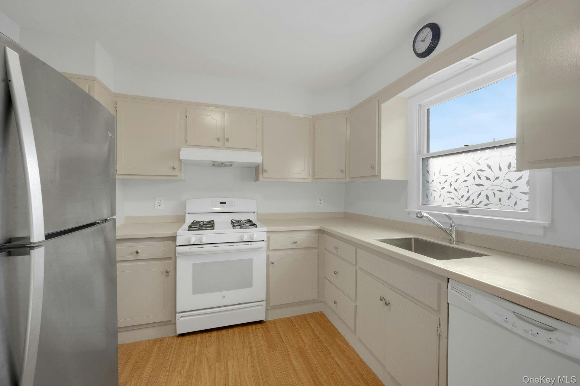 52 Post Place, Unit 2 Harrison, NY 10528 - Photo 10 of 23 a kitchen with a sink cabinets stainless steel appliances and a window