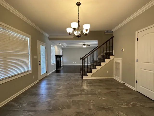 a view of a hallway with wooden floor and staircase