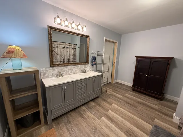 a view of a pathway both side of building with yard in back