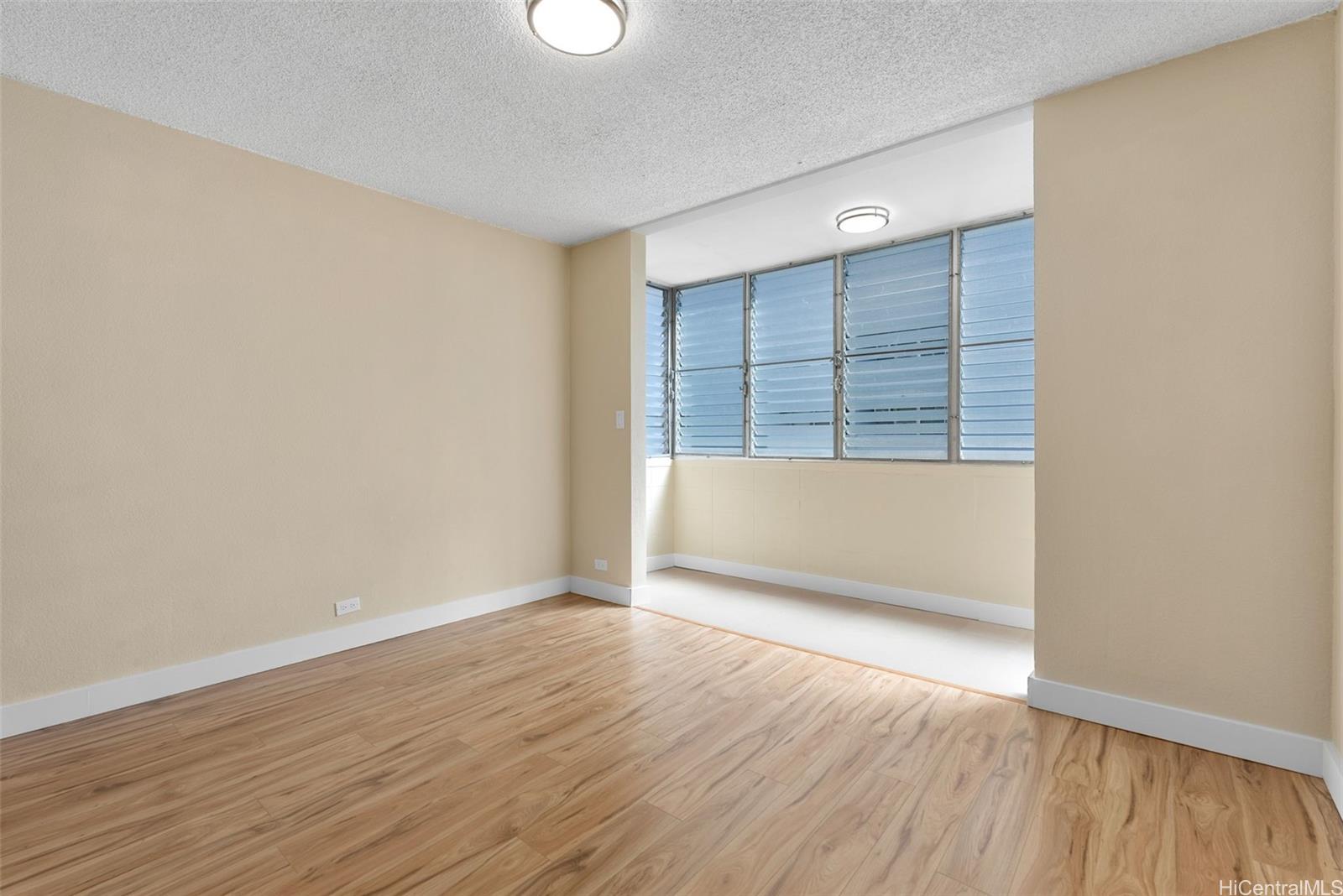 814 Kinau Street, Unit 401 Honolulu, HI 96813 - Photo 6 of 23 an empty room with wooden floor and windows