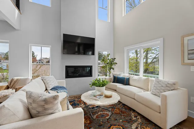 a living room with furniture fireplace and a large window