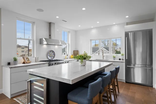 a kitchen with kitchen island a table chairs stove and refrigerator