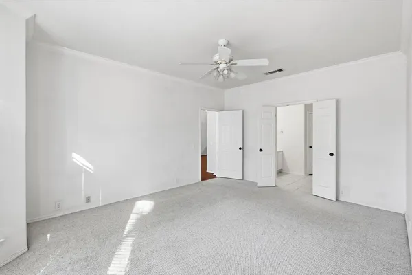 a view of an empty room with a ceiling fan