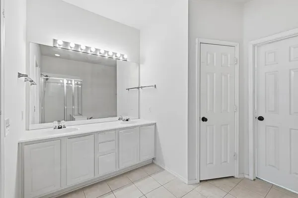 a bathroom with a double vanity sink and a mirror