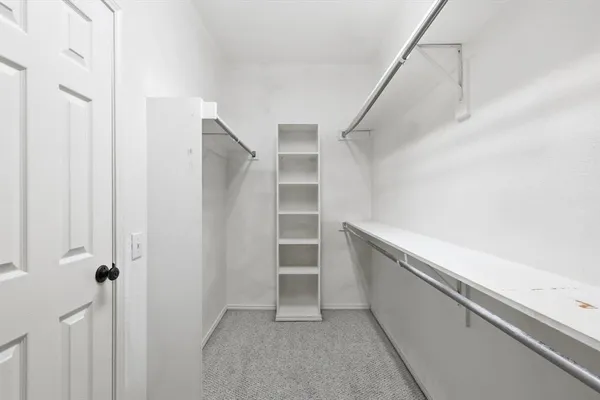 a view of walk in closet with empty racks