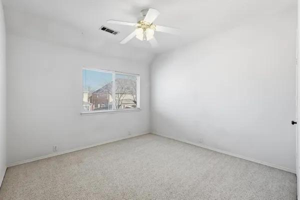 an empty room with a window and a ceiling fan