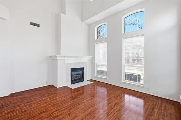 a view of empty room with wooden floor and fireplace