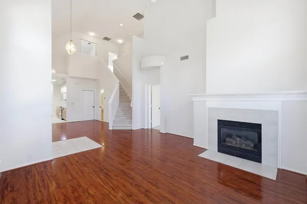 a view of a livingroom with wooden floor and a fireplace