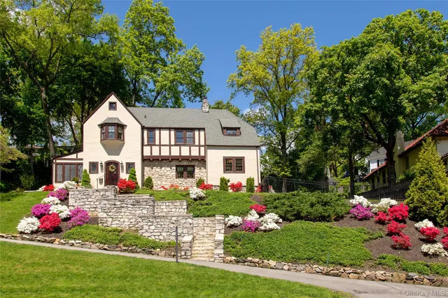 a front view of house with yard and flowers around