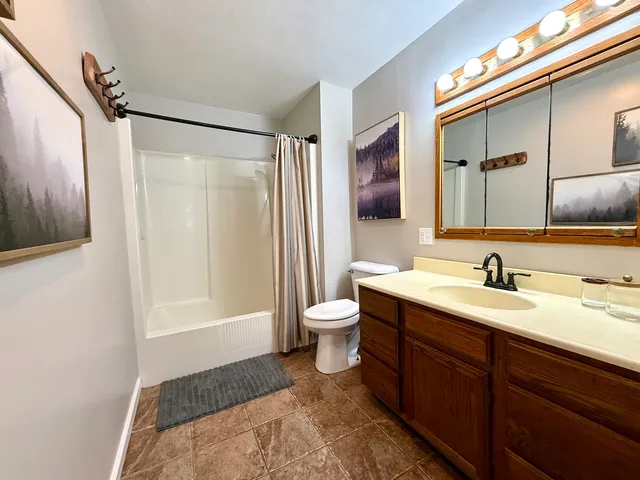 a bathroom with a granite countertop sink toilet and shower
