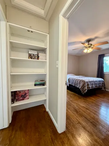 a view of a bedroom with furniture and wooden floor