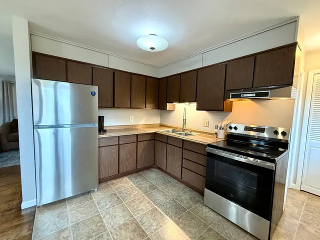 a kitchen with a refrigerator stove and cabinets