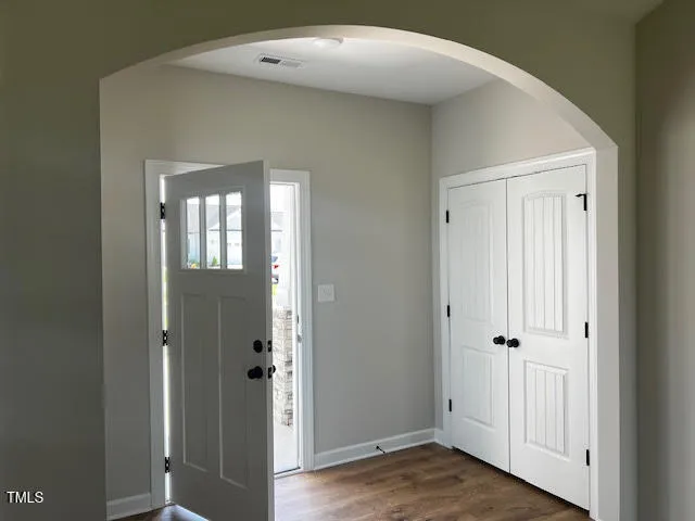 a view of a hallway with wooden floor and staircase