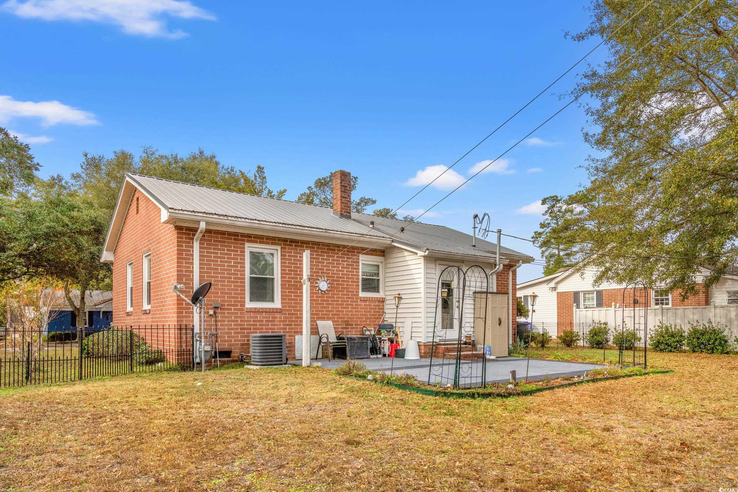 324 Edgewood Circle Conway, SC 29527 - Photo 26 of 31 Rear view of house featuring a patio, brick siding, a chimney, and a metal roof