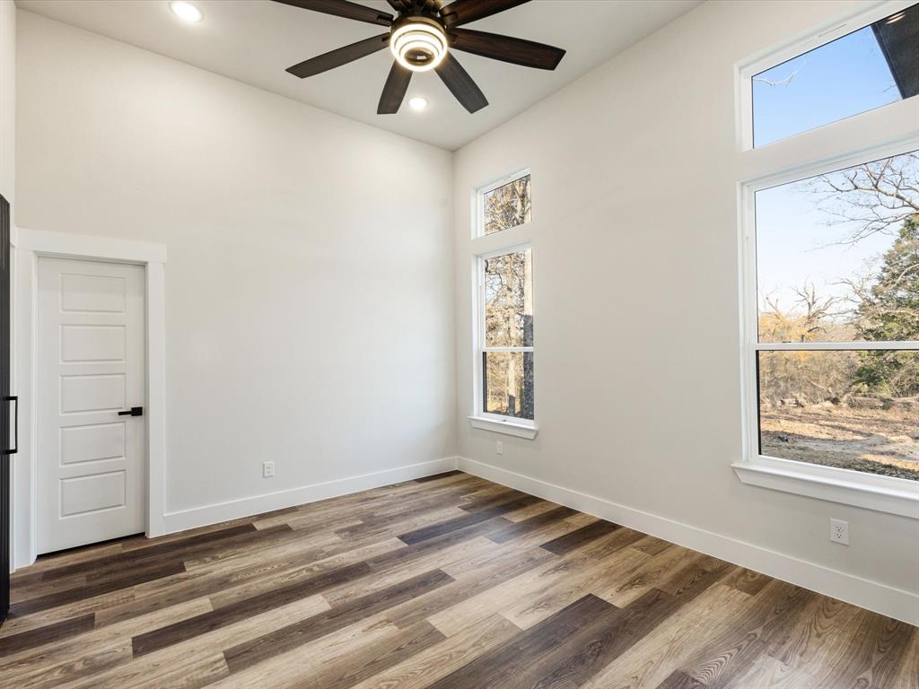 5018 Point La Vista Road Malakoff, TX 75148 - Photo 21 of 32 Spare room with wood finished floors, ceiling fan, recessed lighting, and a high ceiling