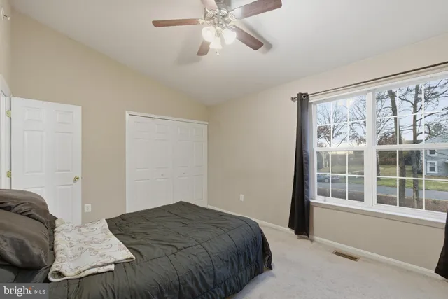 a bedroom with a bed and a large window