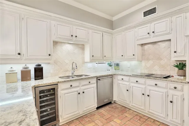 a kitchen with granite countertop white cabinets white stainless steel appliances and sink