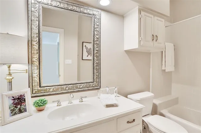 a bathroom with a sink vanity mirror and toilet