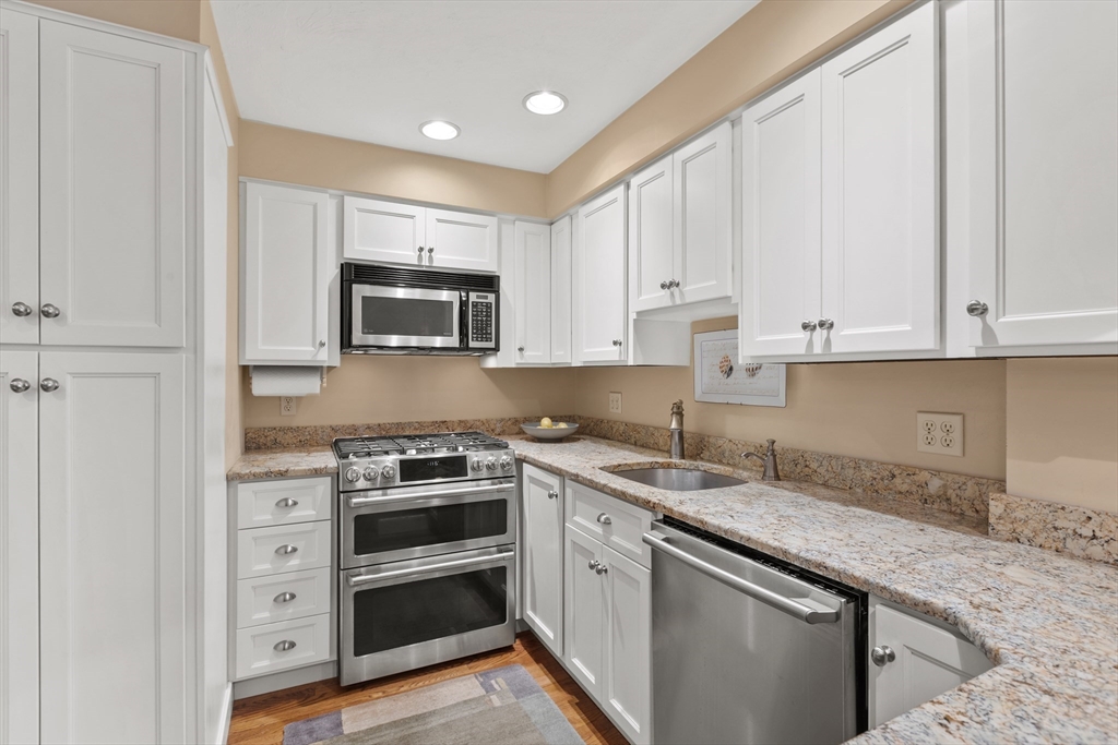 29 Allen Road Winchester, MA 01890 - Photo 14 of 42 a kitchen with granite countertop white cabinets and stainless steel appliances
