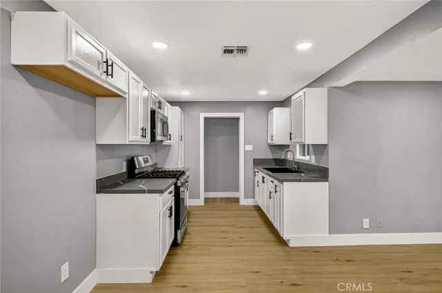 a large kitchen with stainless steel appliances granite countertop a sink and stove