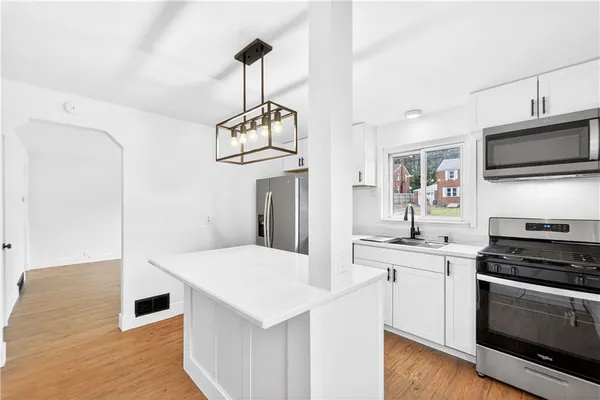 a kitchen with stainless steel appliances a stove sink microwave and cabinets