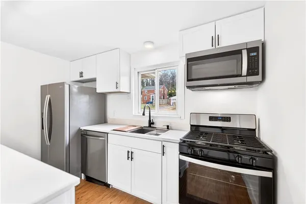 a kitchen with stainless steel appliances a stove microwave and sink