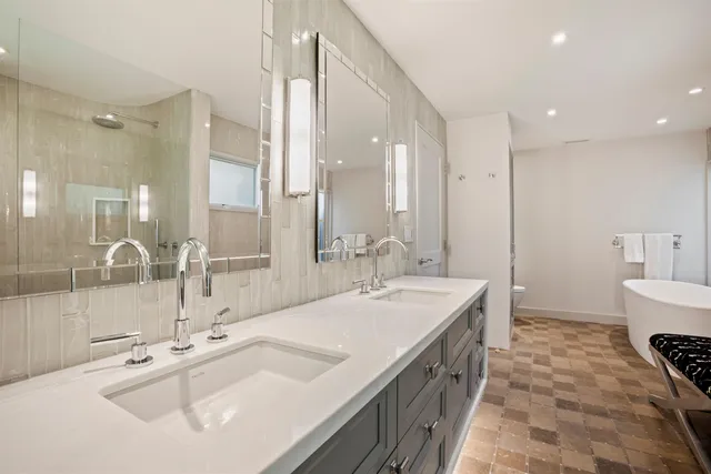 a spacious bathroom with a double vanity sink mirror and double