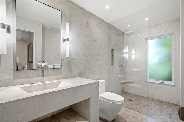 a bathroom with a sink a toilet and shower