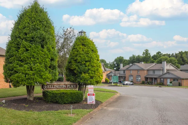 a sign board with buildings in the background