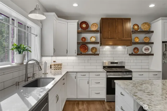 a kitchen with stainless steel appliances granite countertop a sink and wooden cabinets
