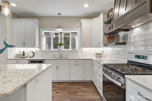 a kitchen with stainless steel appliances granite countertop a sink stove and cabinets