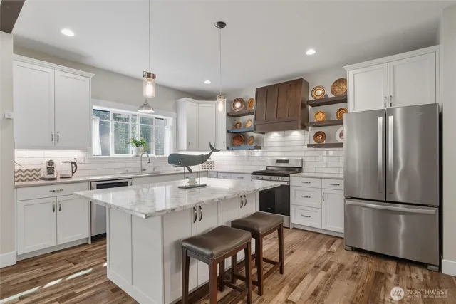 a kitchen with stainless steel appliances granite countertop a sink stove and refrigerator