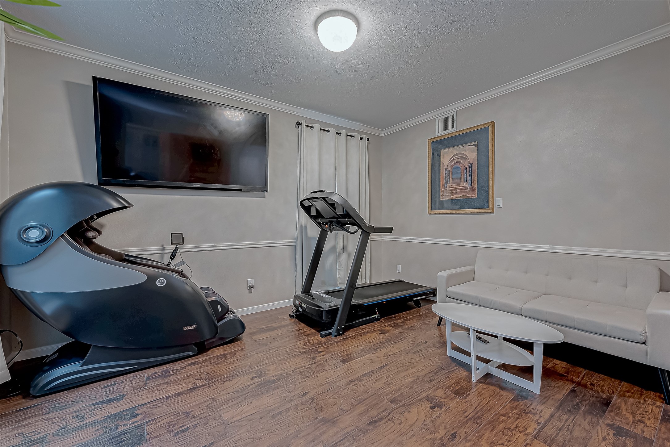 22922 Montclair Park Lane Spring, TX 77373 - Photo 9 of 46 a room with gym equipment and a flat screen tv